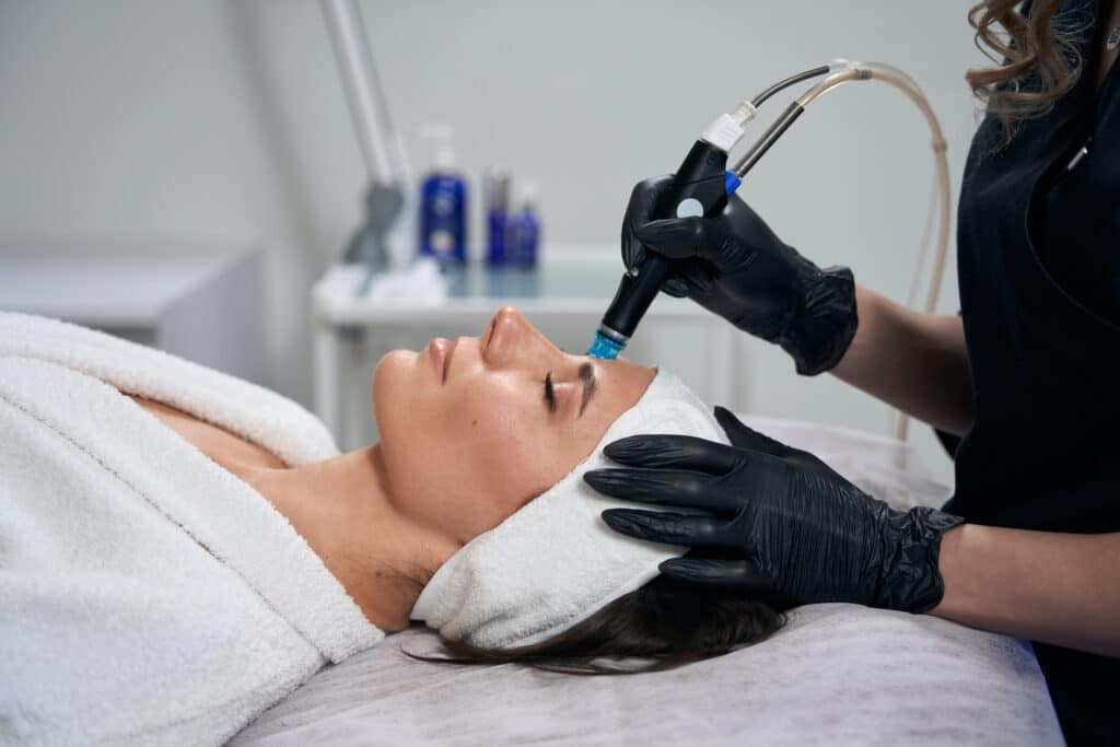 Beautician doing facial skin rejuvenation for pretty female Home